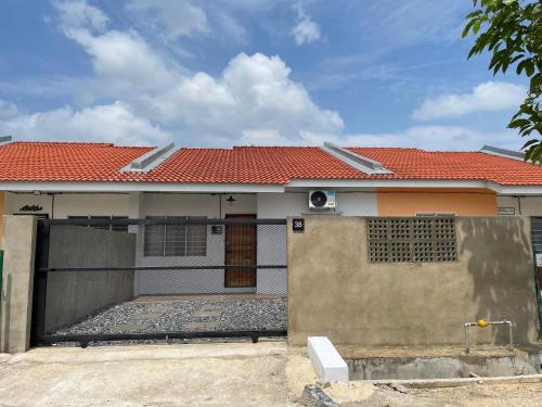 a house with a gate and a red roof at Lit-lit in Kangar