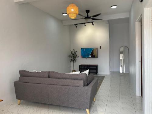 a living room with a couch and a ceiling fan at Lit-lit in Kangar