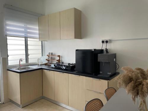 a kitchen with a sink and a microwave at Lit-lit in Kangar