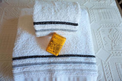 a white towel with a yellow tag on it at Casa de Campo Neves in Montalegre