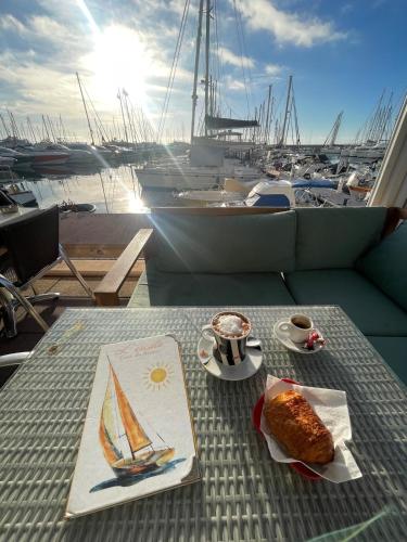 - une table avec un gâteau et du café ainsi qu'un voilier dans l'établissement Le Coeur de Golfe Juan - aircon - 9 min to sea, à Vallauris