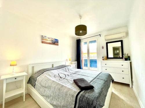 une chambre blanche avec un lit et un miroir dans l'établissement Le Coeur de Golfe Juan - aircon - 9 min to sea, à Vallauris