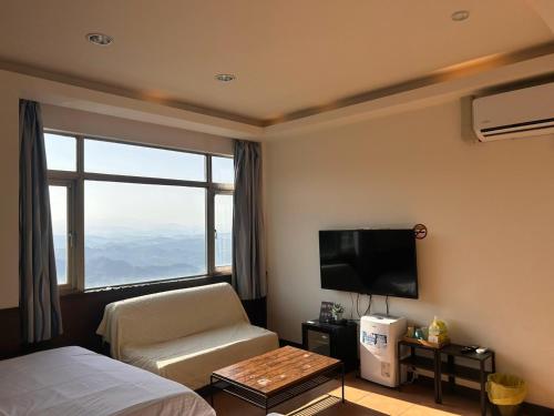 a hotel room with a bed and a tv and a chair at Old Street Seaview Homestay in Jiufen