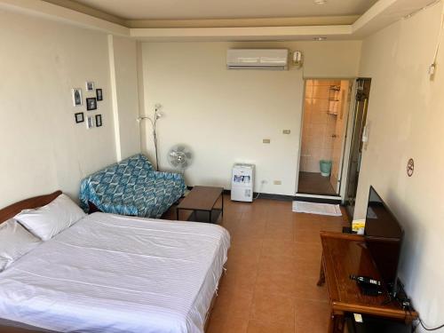 a bedroom with a bed and a tv and a table at Old Street Seaview Homestay in Jiufen
