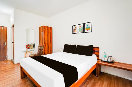 a bedroom with a black and white bed and a desk at Super Collection O Bannergatta Road Near Decathlon in Bengaluru