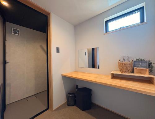 a bathroom with a wooden counter and a mirror at My Place 小豆島 1日1組限定 海近の贅沢ステイ 2025年フルリノベ 洗練モダンデザイン 最大8名 一棟貸切 in Tonosho