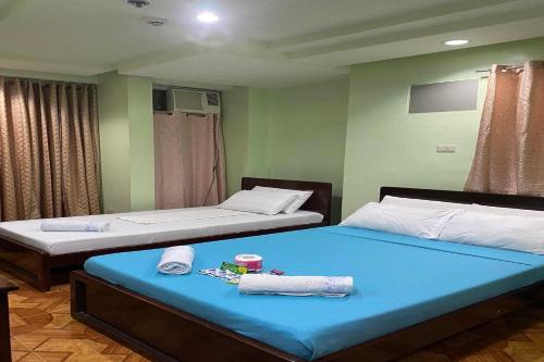 two beds sitting next to each other in a room at Voyagers Palace in Puerto Princesa City