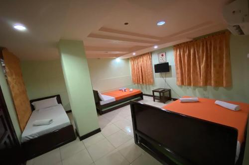a room with two beds and a tv in it at Voyagers Palace in Puerto Princesa City