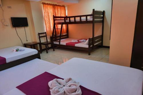 a room with two bunk beds and a tv at Voyagers Palace in Puerto Princesa City