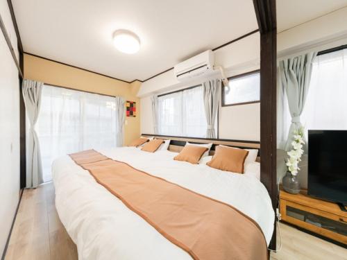a bedroom with a large bed and a flat screen tv at Shibuya Area ,Ebisu 3min walk,Harajuku 2min,Queen Bed,Switch,Free Wi-Fi , PocketWi-Fi in Tokyo