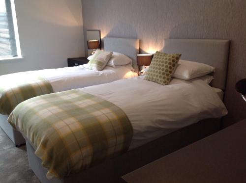 two beds sitting next to each other in a bedroom at Rooms @ Number Six in Oakham