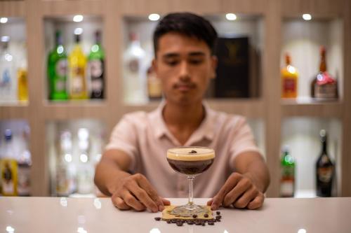 a man sitting at a bar with a drink at Bhotekoshi Heli Resort in Phalāmsāngu