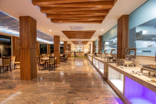 a restaurant with wooden ceilings and tables and chairs at Bhotekoshi Heli Resort in Phalāmsāngu
