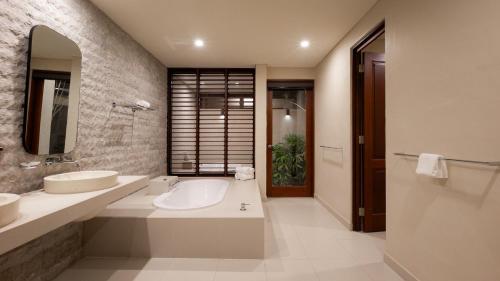 a bathroom with two sinks and a mirror at Niramaya Villas and Spa in Port Douglas