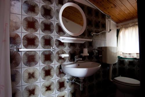 baño con lavabo y espejo en la pared en La Casa Del Mito en Marina di Modica