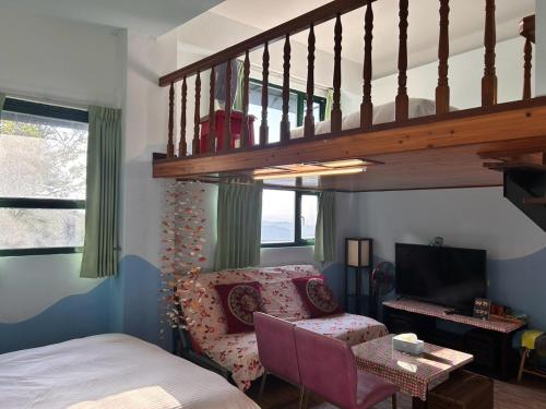 a bedroom with a bed and a chair and a staircase at Old Street Seaview Homestay in Jiufen