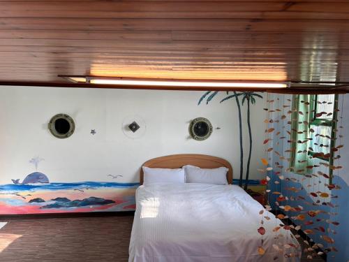 a bedroom with a bed with a painting on the wall at Old Street Seaview Homestay in Jiufen
