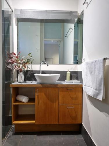 a bathroom with a sink and a mirror at Eco Gallery Apartment in Fremantle