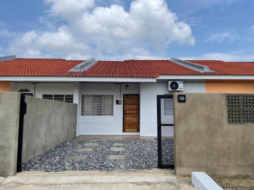 a house with a gate and a red roof at Lit-lit in Kangar