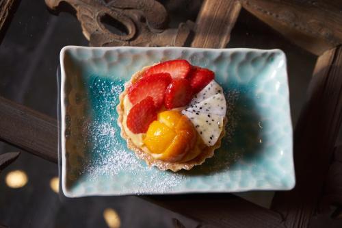 a dessert with fruit on a blue plate at Yangshuo Village Inn Boutique Hotel in Yangshuo