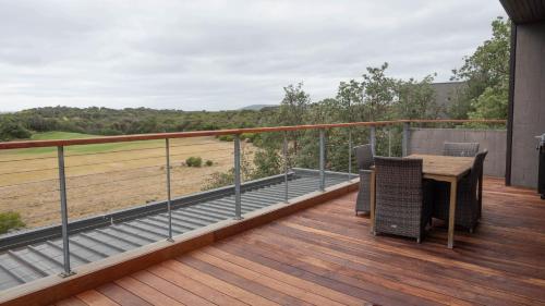 a balcony with a table and chairs on a deck at St Andrews Beach Golf Club Apartment 5 04 in Fingal