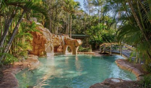 a pool in a theme park with a water slide at Ocean Tropics Lush Villa at Aanuka Resort in Coffs Harbour