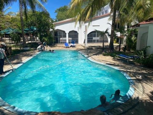 a large blue pool with three people sitting in it at Maasai Koroga Hotel & Apartments in Mombasa