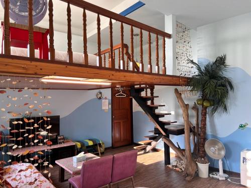 a living room with a wooden staircase in a house at Old Street Seaview Homestay in Jiufen