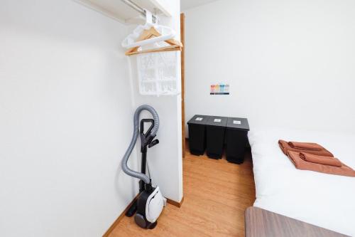 a room with a vacuum in the corner of a room at Zenith Garden TOGOSHI in Tokyo