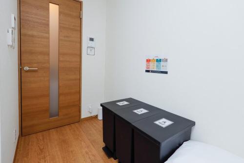 a room with a bed and a wooden door at Zenith Garden TOGOSHI in Tokyo