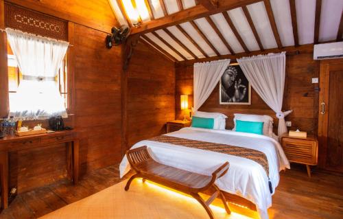 a bedroom with a bed and a chair and a window at Bintan Exotica Resort By WH - Free Shuttle BBT Resort BBT - Free Breakfast in Berakit