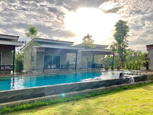 a house with a swimming pool in the yard at บ้านไร่แสงเดือน รีสอร์ท in Ban Kha