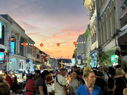 a crowd of people walking down a busy city street at Twelve 8 Boutique House in Phuket Town