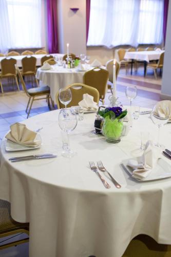 a table with white table cloths and wine glasses on it at Hotel Przedwiośnie in Masłów