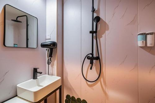 a bathroom with a sink and a shower at Qiqiaowu Hotel Beijing Daxing Airport Line Caoqiao Subway Station Branch in Beijing