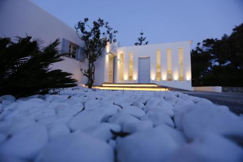 a house with a snow covered driveway at night at Aeolos Resort in Mýkonos City