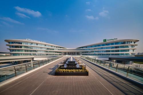 a large building with a walkway in front of it at Crowne Plaza Wuhan Tianhe Airport by IHG in Wuhan