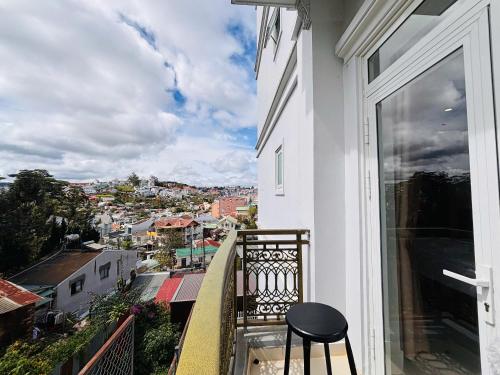 a stool on a balcony with a view of a city at Bee Luxury Dalat Hotel in Xuan An