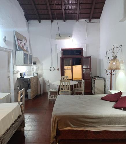 a room with two beds and a table and a kitchen at Casita B in Asuncion