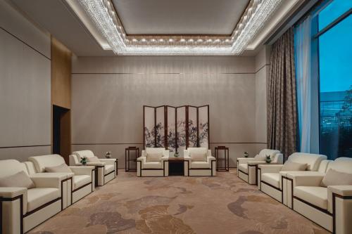 a rendering of a waiting room with chairs and tables at Crowne Plaza Wuhan Tianhe Airport by IHG in Wuhan