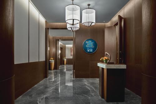 a lobby with a hallway with a sign on the wall at Crowne Plaza Wuhan Tianhe Airport by IHG in Wuhan