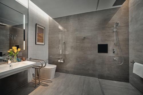 a bathroom with a shower and a toilet and a sink at Crowne Plaza Wuhan Tianhe Airport by IHG in Wuhan