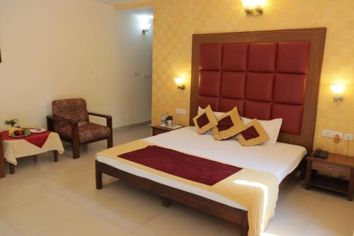 a bedroom with a large bed with a red headboard at Design Galleries Complex in Faridabad