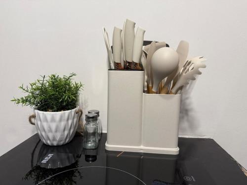 two white containers filled with utensils on a table at Olum Beach Loft in Antón Lizardo