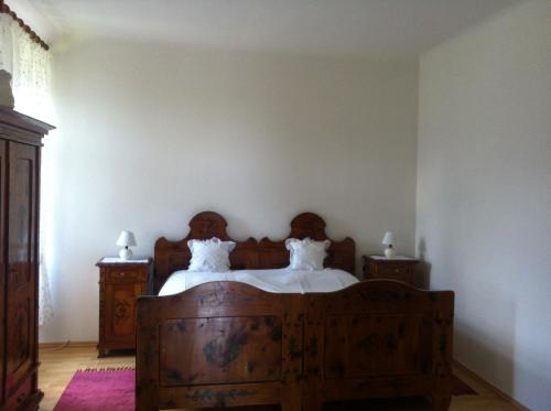 Schlafzimmer mit einem Holzbett mit weißer Bettwäsche in der Unterkunft Villa Martiny in Seeboden