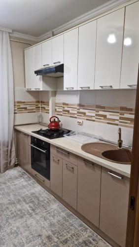 a kitchen with white cabinets and a sink at AIRPORT&APARTMENT&parking in Chişinău