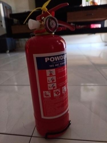 a red fire extinguisher is sitting on the floor at CosY Klebang Homestay in Kampong Lereh
