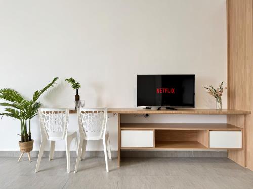 a living room with a desk with a tv and two chairs at Sunsuria Forum SOHO & Residence Suites Setia Alam by MOKA in Shah Alam