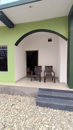 two chairs sitting on the outside of a building at Dooars Panorama Nature's Nest in Chālsa Mahābāri