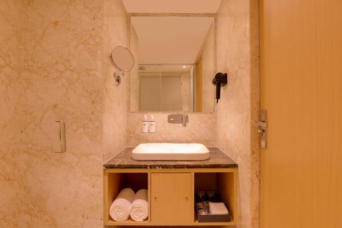 a bathroom with a sink and a mirror at Keys Prima by Lemon Tree Hotels, Kota, Rajasthan in Kota